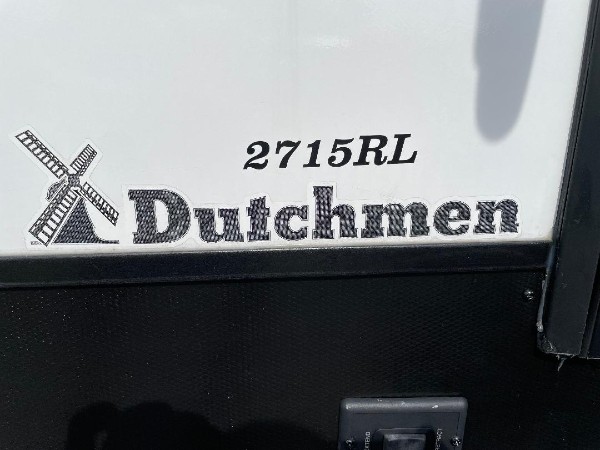 A Dutchmen reading on the side of a Coleman camper.