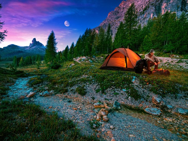 a hiker by his tent at nighttime