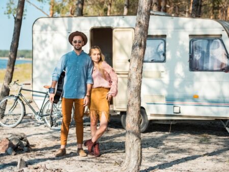 A couple taking a picture outside their camper