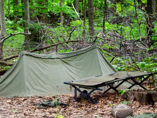 A camping cot next to the tent