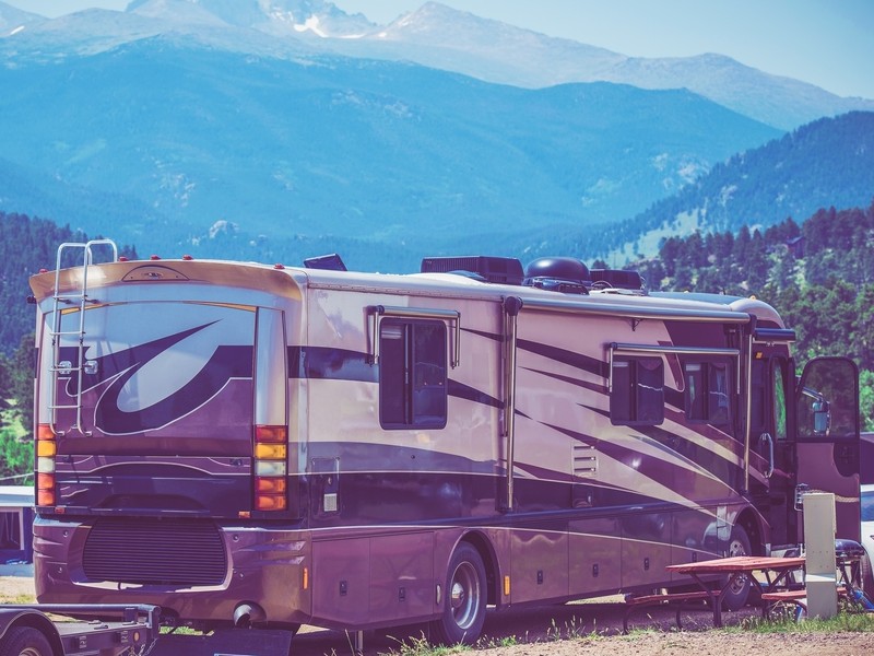 A parked class A RV with mountains in the view