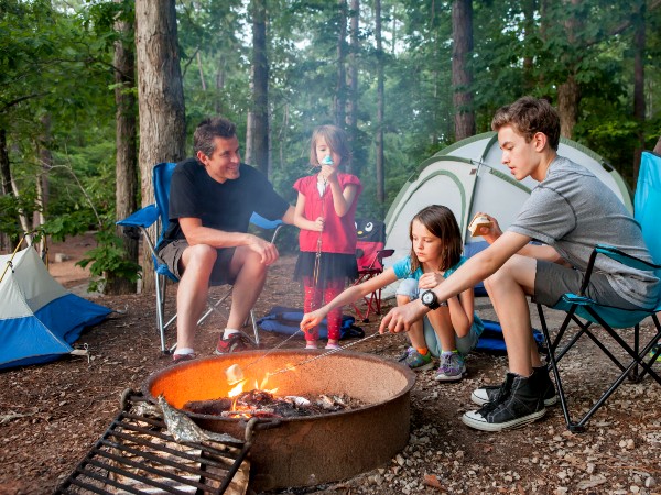 A father with his kids next to a campfire