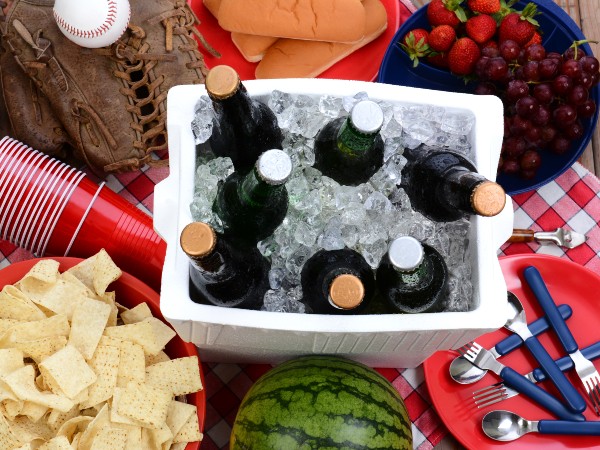 Food, drinks and utensils by an ice chest filled with drinks