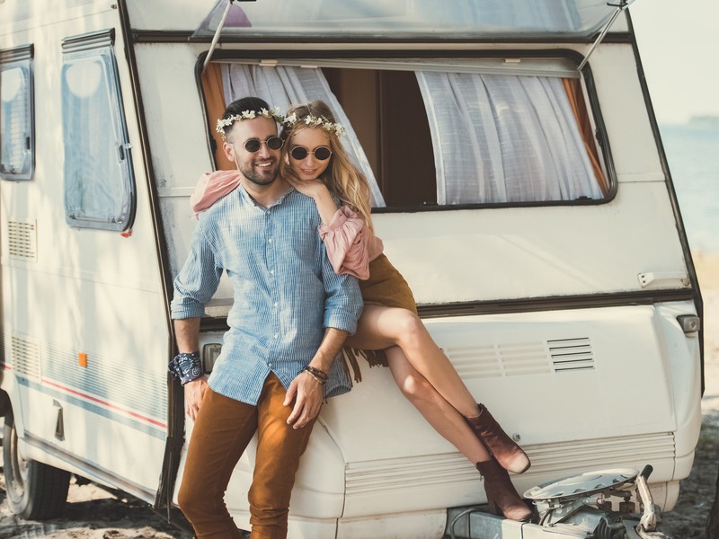 A couple outside of their camper for a photo