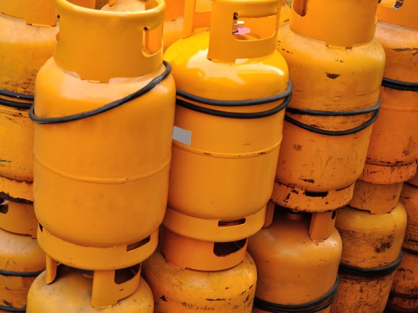 A bunch of yellow propane tanks lined up