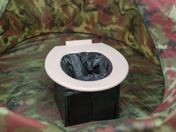 A white seated toilet in a tent