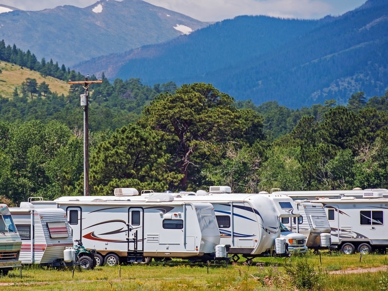 Campers lined up at a campground by the mountains.