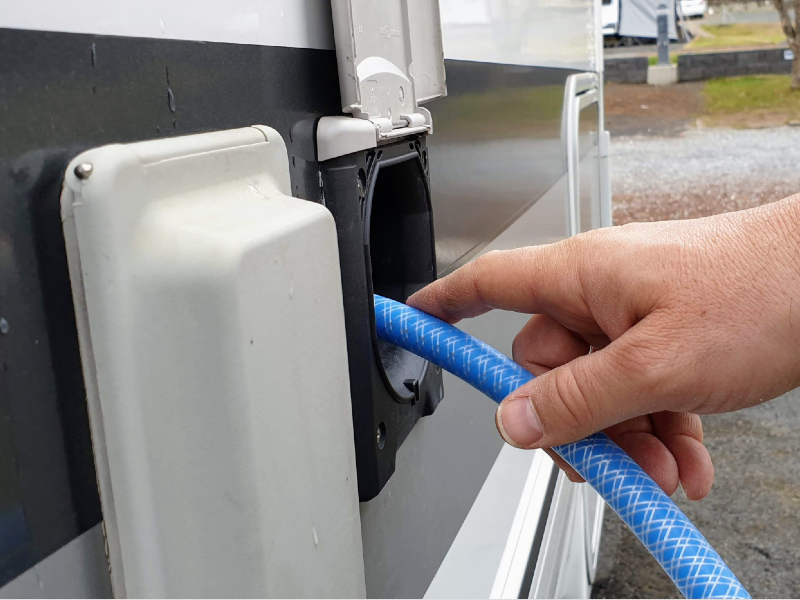 A blue hose being used in a camper