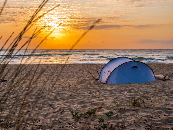 A blue tent on the beach for camping