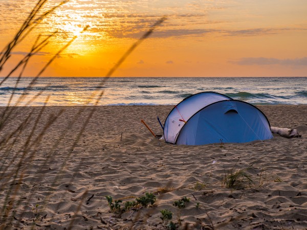 A tent on the beach at sunset