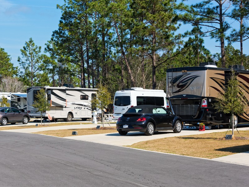 A parked RV after towing a car to a campground